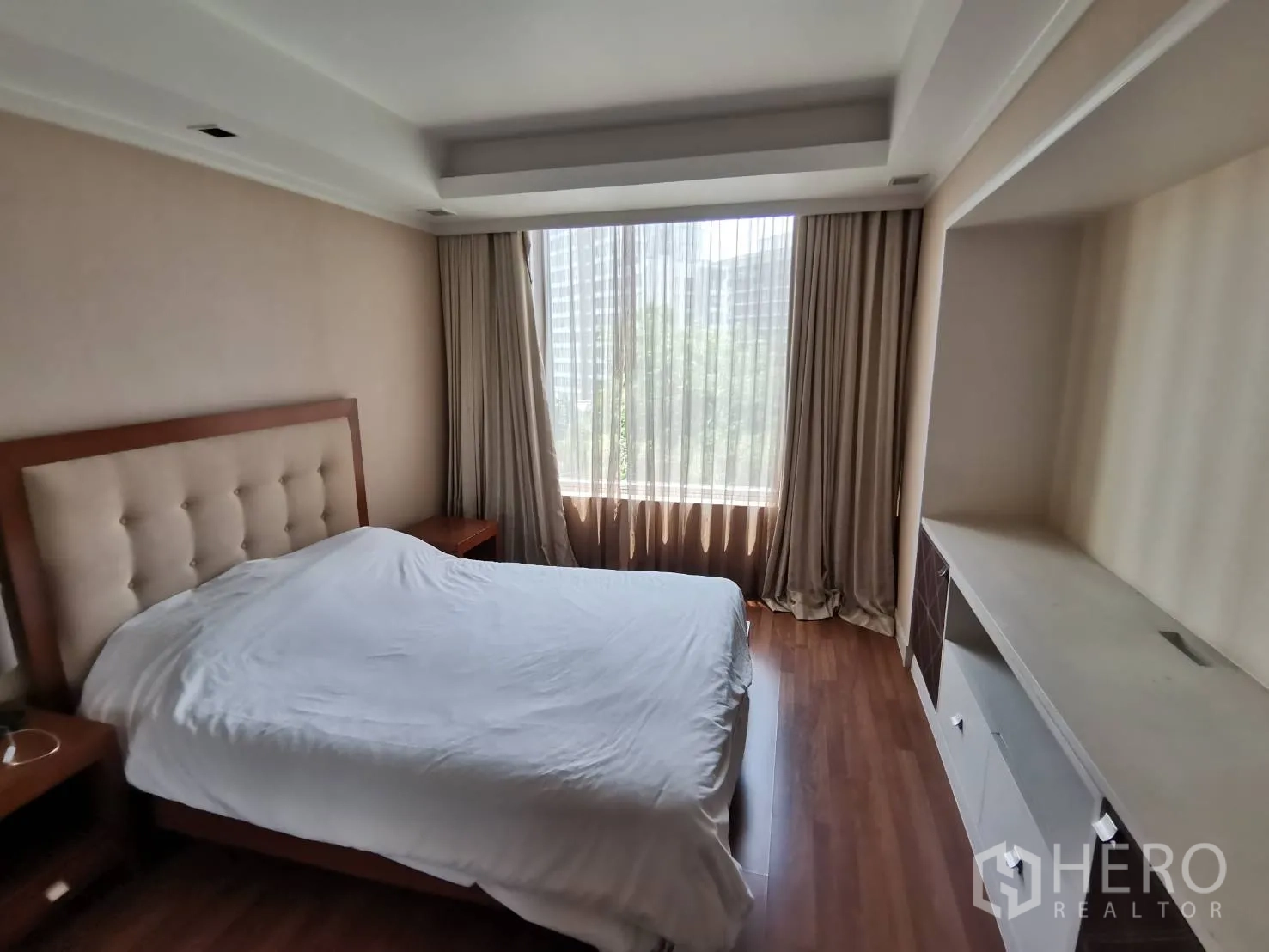 คอนโด ให้เช่าในPathum Wan, Bangkok - ห้องนอนเตียงใหญ่ หัวเตียงบุผ้า หน้าต่างบานกว้างพร้อมผ้าม่าน พื้นไม้ และชั้นบิวท์อิน