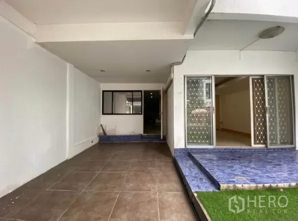 ทาวน์เฮาส์ ให้เช่าในKhlong Toei, Bangkok - ที่จอดรถในร่มและลานหน้าบ้าน พร้อมประตูบานเลื่อนและขั้นกระเบื้องสีน้ำเงินของทาวน์เฮ้าส์ในกรุงเทพฯ