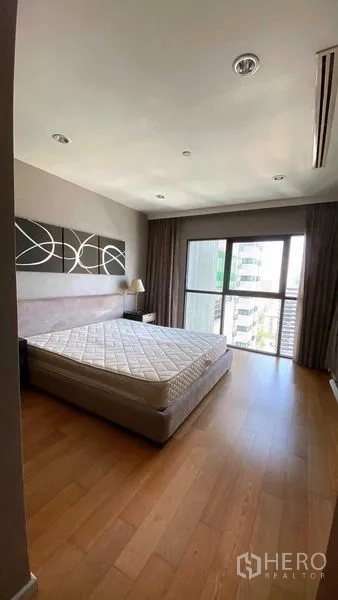 คอนโด ให้เช่าหรือขายในSathon, Bangkok - ห้องนอนสว่าง เตียงควีน พื้นไม้ และหน้าต่างสูงเต็มบานมองเห็นวิวเมือง