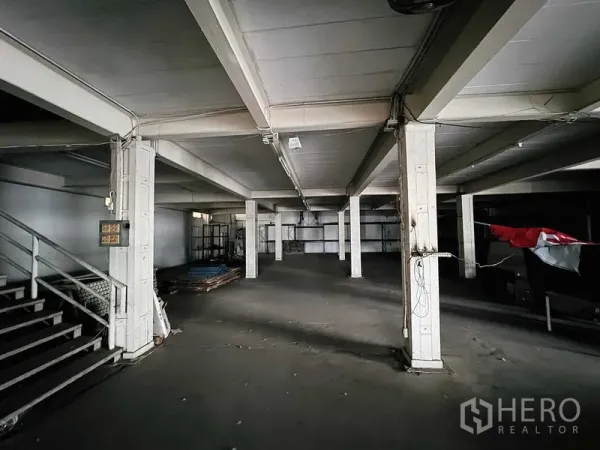 展厅 出租在Min Buri, Bangkok - 底层开放式空间，混凝土柱与楼梯，适合仓储或陈列。