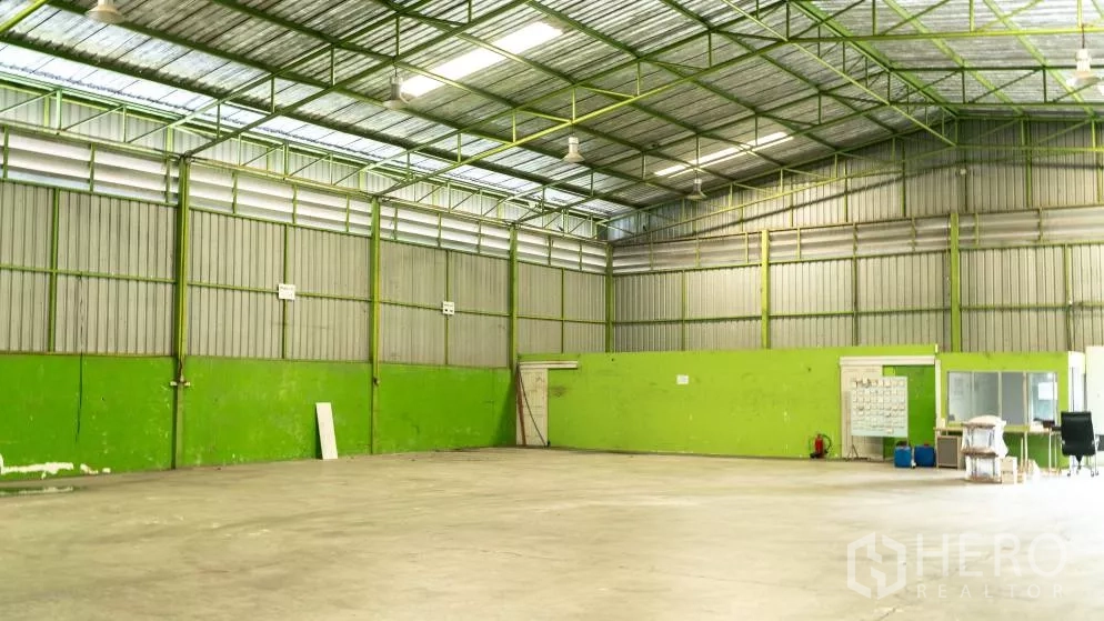 คลังสินค้า ให้เช่าในThanyaburi, Pathum Thani - อาคารโกดังสว่าง ผนังทาสีเขียว ช่องระบายอากาศ และไฟส่องสว่างแขวน