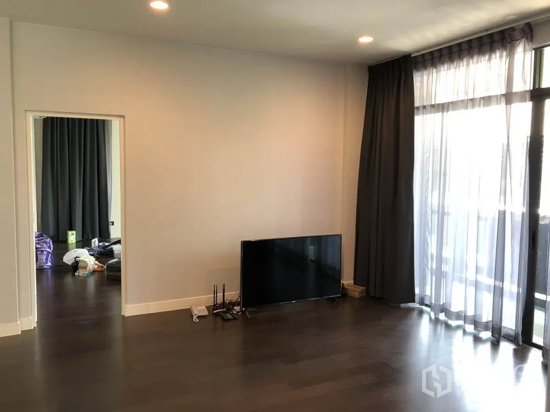 Detached House for rent or sale in Bang Kapi, Bangkok - Upstairs living room with floor-to-ceiling curtains, dark wood flooring and TV point.