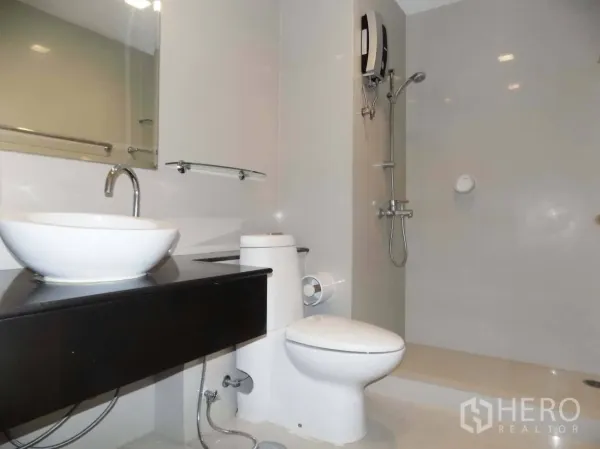 Condominium for rent or sale in Khlong Toei, Bangkok - Contemporary bathroom featuring vessel sink, countertop, toilet and walk-in shower with water heater.