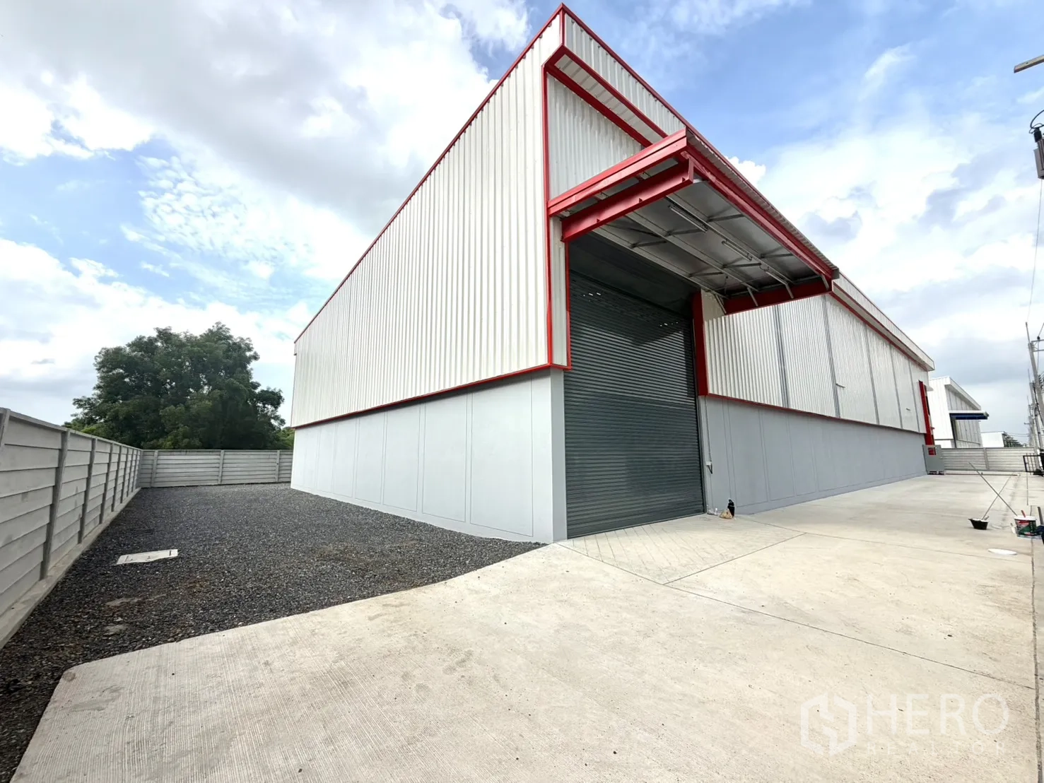 Factory for rent or sale in Lam Luk Ka, Pathum Thani - Loading bay with a large roller shutter and broad concrete apron.