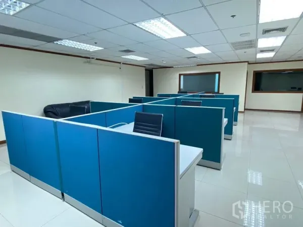 Office Space for rent in Huai Khwang, Bangkok - Open-plan workspace with blue partitioned cubicles and fluorescent lighting.