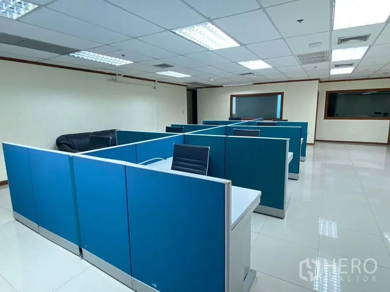 Office Space for rent in Huai Khwang, Bangkok - Open-plan workspace with blue partitioned cubicles and fluorescent lighting.