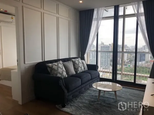 Condominium for rent in Khlong Toei, Bangkok - Living room with floor-to-ceiling windows and sweeping Bangkok skyline view.