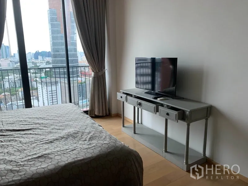 คอนโด ให้เช่าในPhaya Thai, Bangkok - ห้องนอนมีหน้าต่างสูงจรดเพดาน โต๊ะวางทีวีกระจก และวิวเมืองจากระเบียง