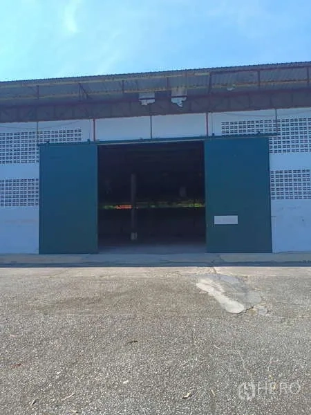 货栈 出租在Mueang Rayong, Rayong - 仓库正面视角，绿色滑门开启，前方混凝土空坪。