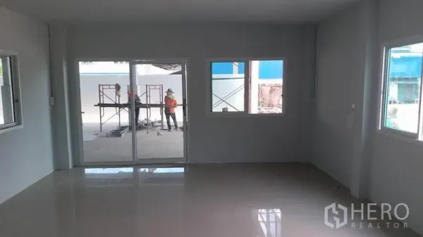 Factory for rent in Krathum Baen, Samut Sakhon - Bright office room with glossy tiled floor, white walls, sliding glass doors and windows looking out to the factory yard.