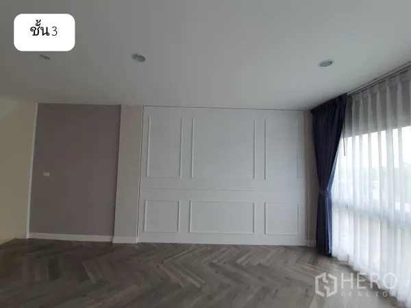 Home Office for rent or sale in Prawet, Bangkok - Third-floor lounge or meeting area with white wall paneling, sheer curtains and dark herringbone floor.