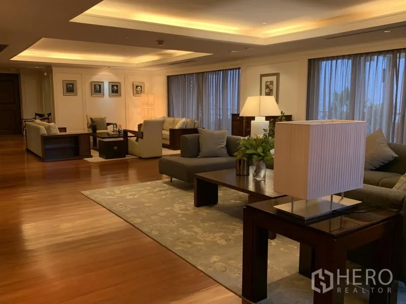 Condominium for rent or sale in Watthana, Bangkok - Open-plan living space with multiple seating zones and warm ambient lighting.