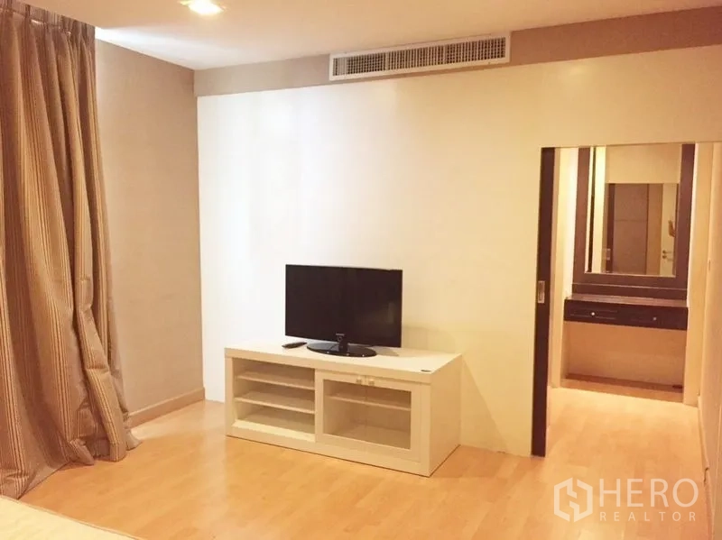 คอนโด ให้เช่าในKhlong Toei, Bangkok - โซนพักผ่อนในห้องนอนพร้อมชั้นวางทีวี เชื่อมต่อสู่พื้นที่แต่งตัว