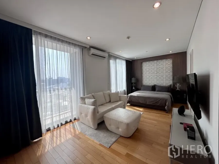 คอนโด ให้เช่าหรือขายในKhlong Toei, Bangkok - ห้องนอนใหญ่สว่างพร้อมโซฟา พื้นไม้ และหน้าต่างเต็มบานมุมมองเมือง