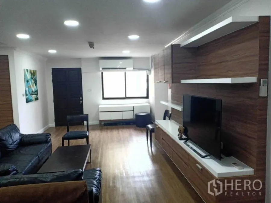 คอนโด ให้เช่าในWatthana, Bangkok - ห้องนั่งเล่นสว่าง พื้นไม้ ชุดชั้นวางทีวีบิวท์อิน และโซฟาหนัง ในคอนโดย่านพร้อมพงษ์