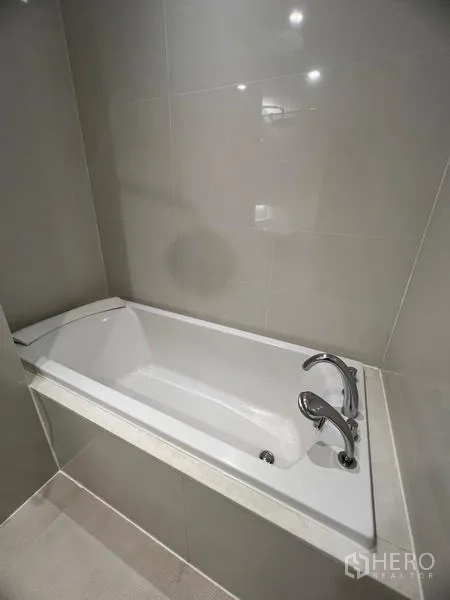 公寓 出租在Khlong Toei, Bangkok - 嵌入式浸泡浴缸特写，配镀铬龙头与瓷砖墙面。