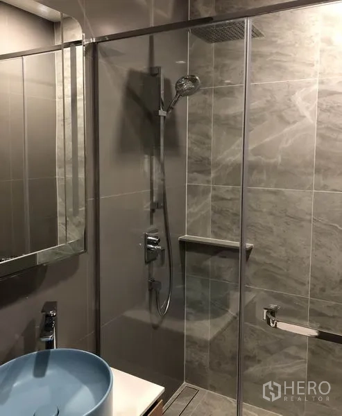 คอนโด ให้เช่าในWatthana, Bangkok - ห้องน้ำสไตล์โมเดิร์นพร้อมตู้กระจกกั้นอาบน้ำ ฝักบัวเรนชาวเวอร์ และอ่างล้างหน้าทรงถังสีฟ้า