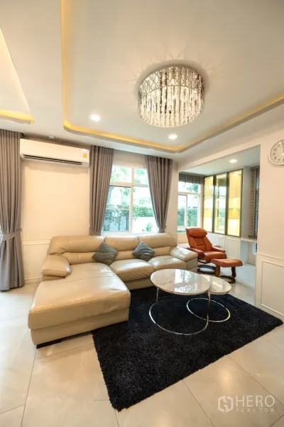 Detached House for rent or sale in Prawet, Bangkok - Bright living room with crystal chandelier, leather sofa and marble coffee tables.