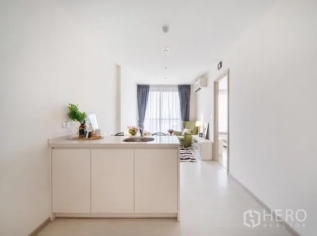 公寓 出售在Khlong Toei, Bangkok - 长形厨房望向采光明亮的客厅与阳台窗。