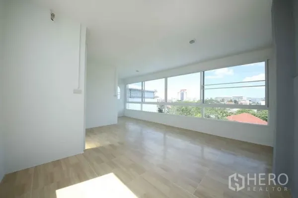 店屋 出租在Wang Thonglang, Bangkok - 楼上房间，整面窗户与城市景观，木纹地板。