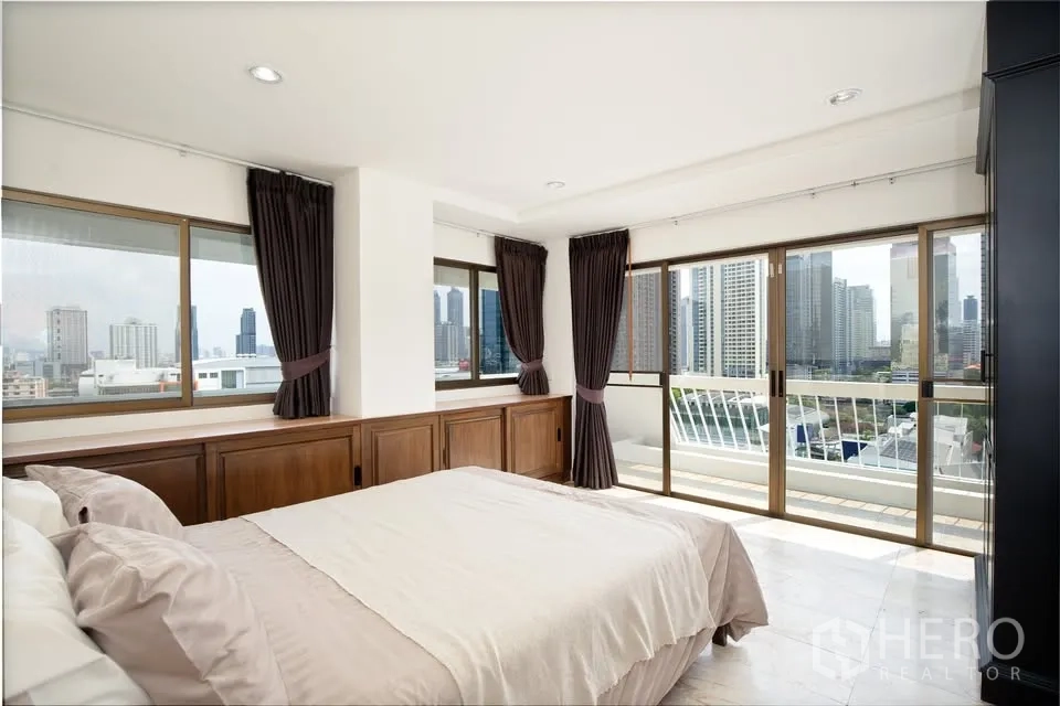 คอนโด for rent in Watthana, Bangkok - ห้องนอนพร้อมหน้าต่างสูงเต็มบานและระเบียงวิวเมือง.