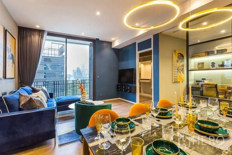 Condominium for rent in Pathum Wan, Bangkok - Open-plan living and dining at Muniq Langsuan condo with ring lights, balcony and city view in Pathum Wan.