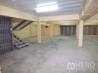 工厂 for rent in Thung Khru, Bangkok - 大面积楼层，带金属楼梯、折叠栅门与顶灯。