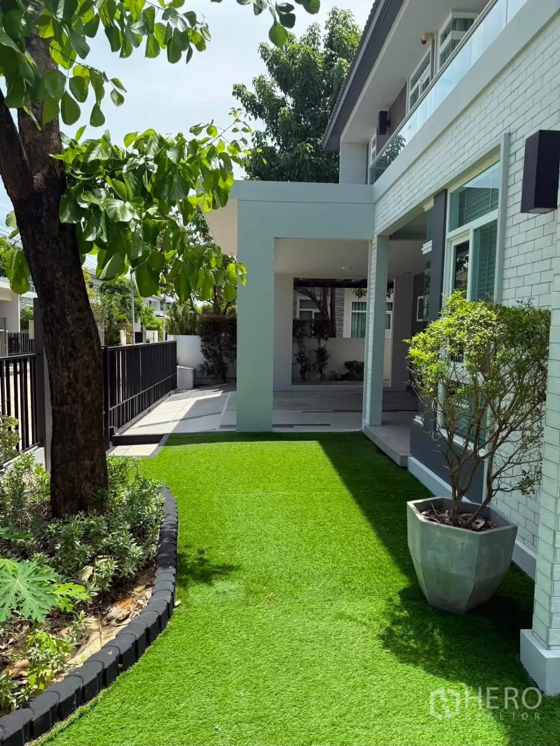 Detached House for rent in Bang Phli, Samut Prakan - Front garden with lawn, trees and covered porch.