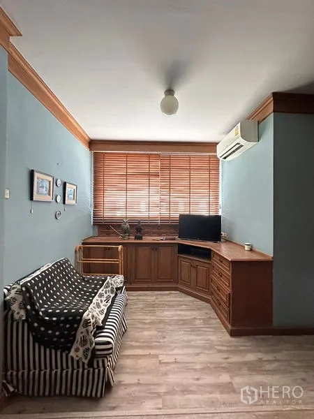 ทาวน์เฮาส์ ให้เช่าในKhlong Toei, Bangkok - ห้องพักผ่อนขนาดกะทัดรัด บิลท์อินไม้ โซฟา และเครื่องปรับอากาศข้างหน้าต่าง