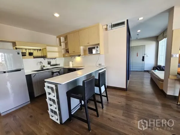 公寓 出售在Phra Khanong, Bangkok - 现代厨房，中央岛台、吧椅、木质橱柜与家电。