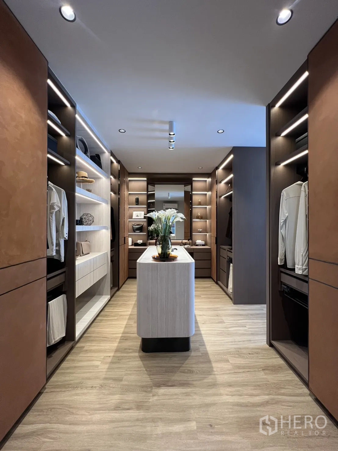 Townhouse for rent in Mueang Samut Prakan, Samut Prakan - Long dressing room corridor with symmetrical closets and ambient lighting.