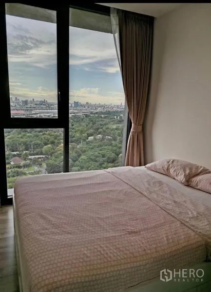 Condominium for rent - Second bedroom with wide window, curtains and expansive park and skyline outlook.