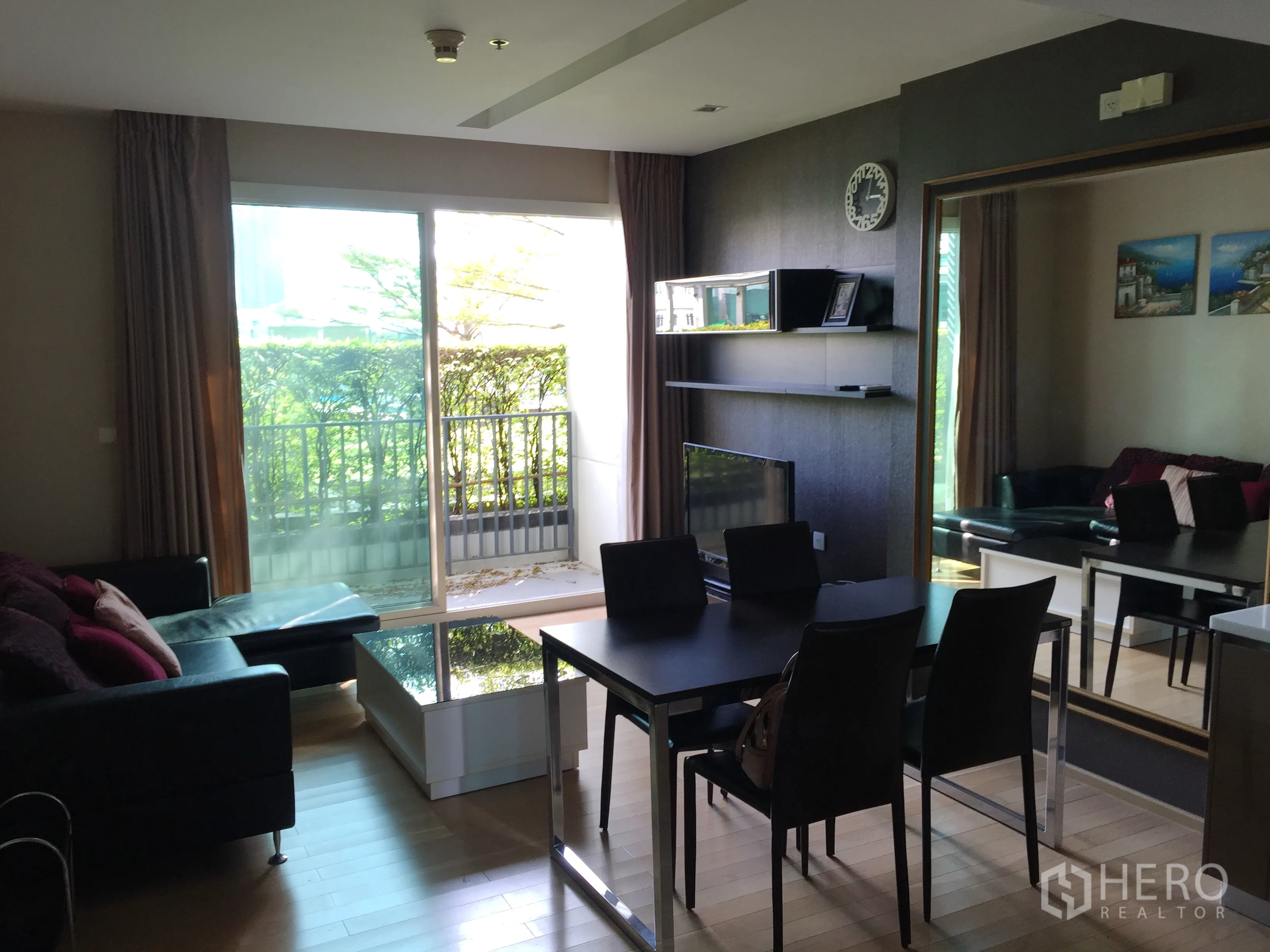 คอนโด ให้เช่าในKhlong Toei, Bangkok - โซนรับแขกและทานอาหารแบบเปิดโล่ง มีโซฟา โต๊ะอาหาร ทีวี และระเบียงมองเห็นสวน