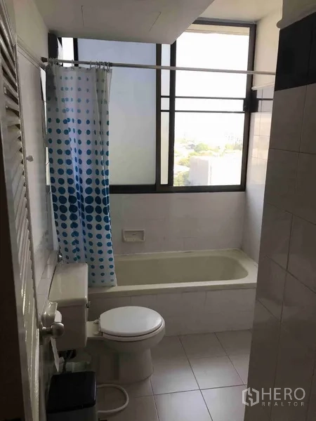 公寓 出租或出售在Watthana, Bangkok - 浴室设浴缸与大窗户，白色瓷砖明亮通透。