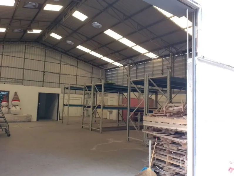 Warehouse for rent in Huai Khwang, Bangkok - Wide entry looking into warehouse with storage racks and ample loading space.