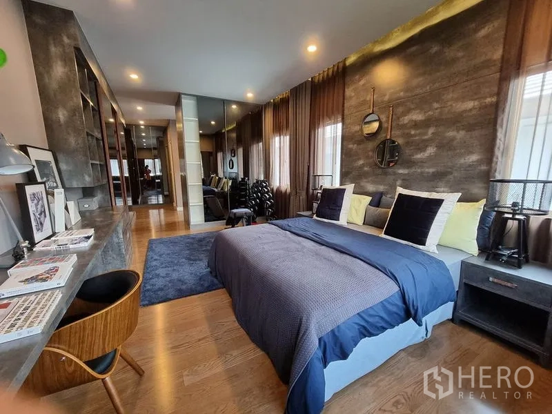 Detached House for rent in Prawet, Bangkok - Stylish bedroom with study desk, mirrored wardrobe and textured feature wall.