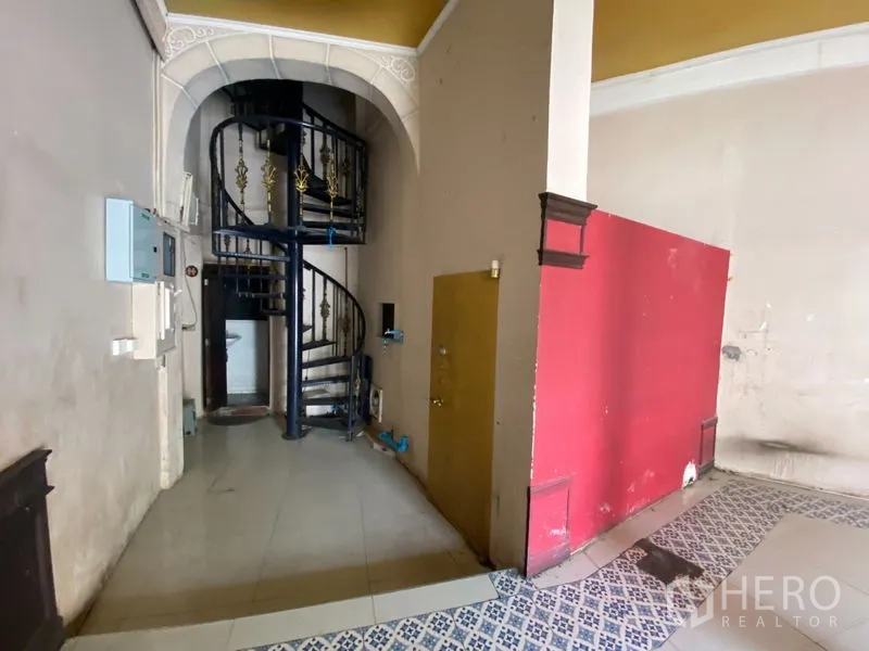 店屋 出租在Phra Nakhon, Bangkok - 金属螺旋楼梯特写，旁有红色隔断墙。