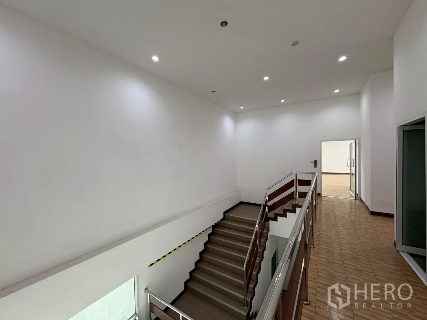 Factory for sale in Bang Bo, Samut Prakan - Women’s restroom with modern cubicles and gray wall tiles.