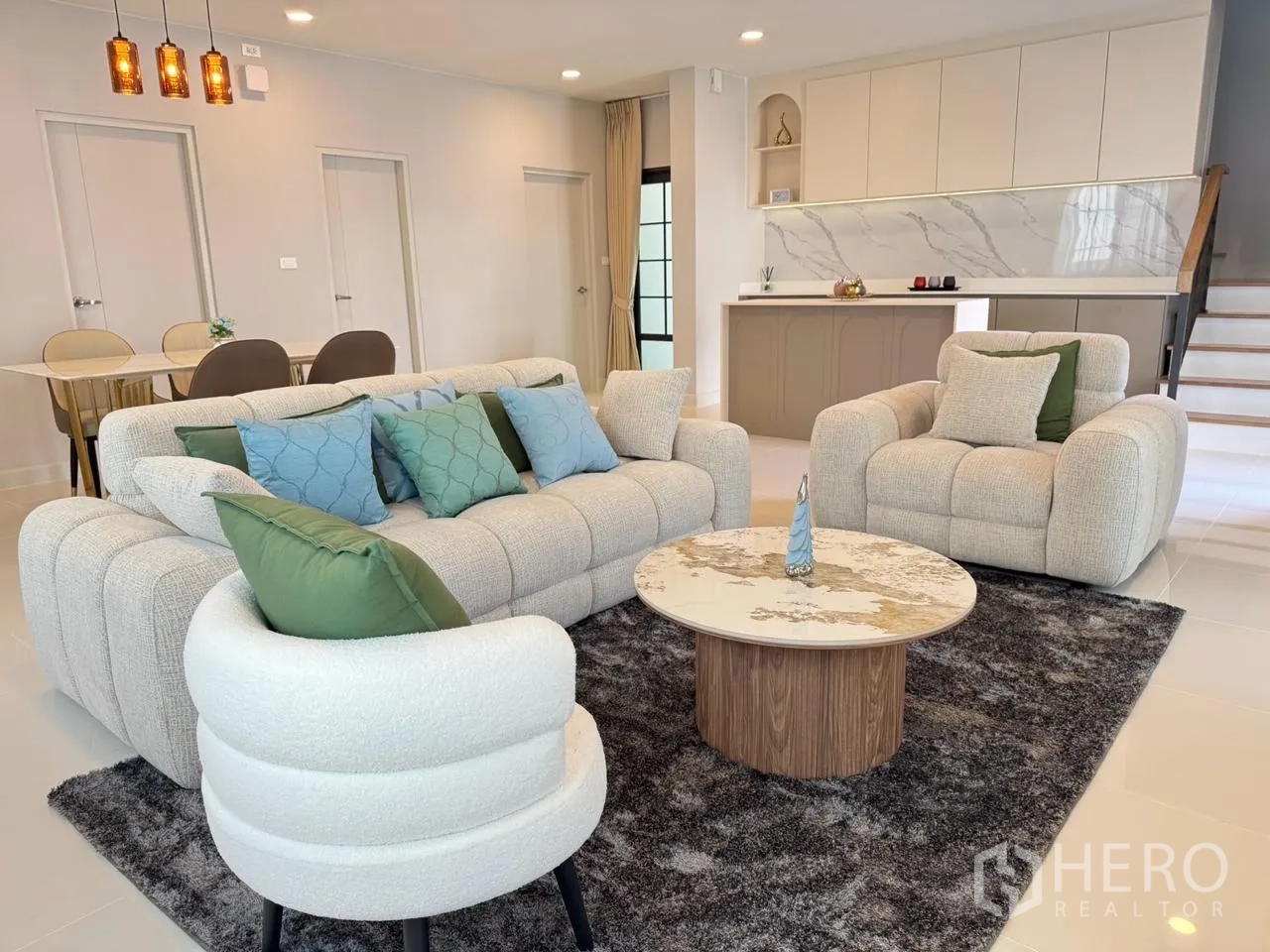 独栋房屋 for rent in Bang Phli, Samut Prakan - 客厅软包沙发组合与圆形茶几置于地毯上。