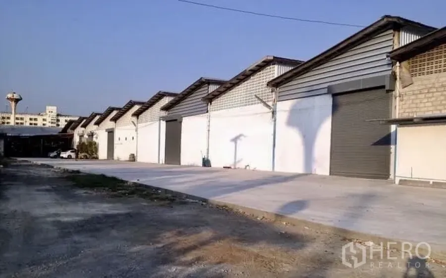 Factory for rent in Bang Pakong, Chachoengsao - Row of factory warehouse units in Bang Pakong with roller shutter doors and a wide concrete loading yard.