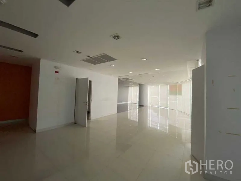 零售空间 出租 - 宽敞展厅区，亮面瓷砖、嵌入式照明与弧形玻璃门面。