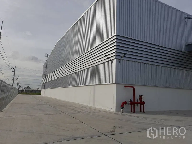 工厂 出租在Mueang Rayong, Rayong - 金属板厂房侧立面，宽车道与可见的消防系统管线。