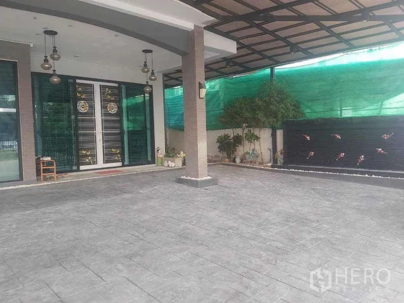 独立式住宅 出租或出售在Prawet, Bangkok - 宽敞的前庭车棚，吊灯与装饰水景墙