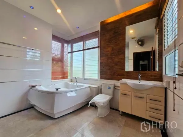 บ้าน ให้เช่าในChatuchak, Bangkok - ห้องน้ำใหญ่สว่าง มีอ่างจากุซซี่มุม ผนังลายไม้ เคาน์เตอร์อ่างล้างหน้า และหน้าต่างบานใหญ่