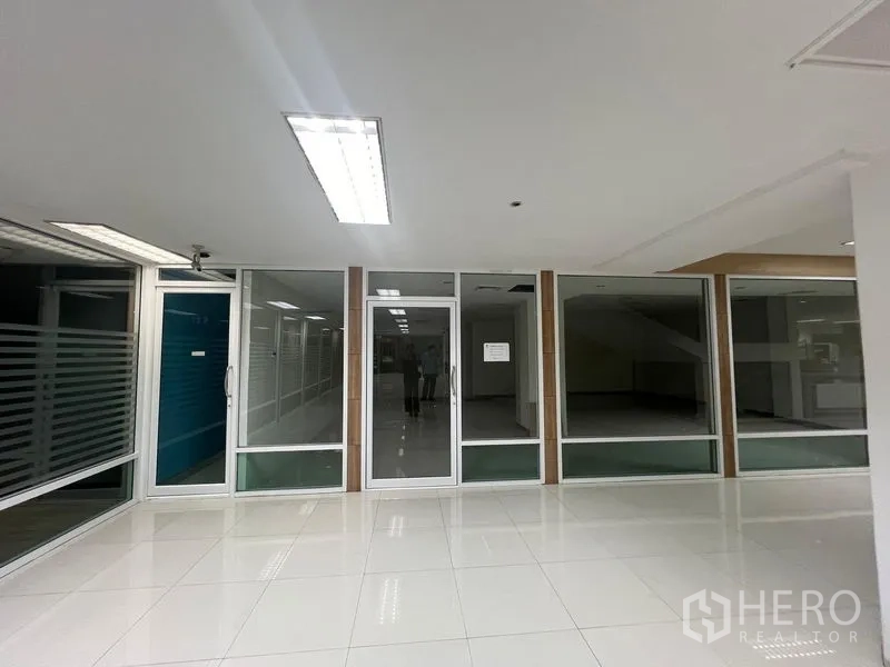 零售空间 出租 - 室内商场内的玻璃店面，中央玻璃门与落地展示窗