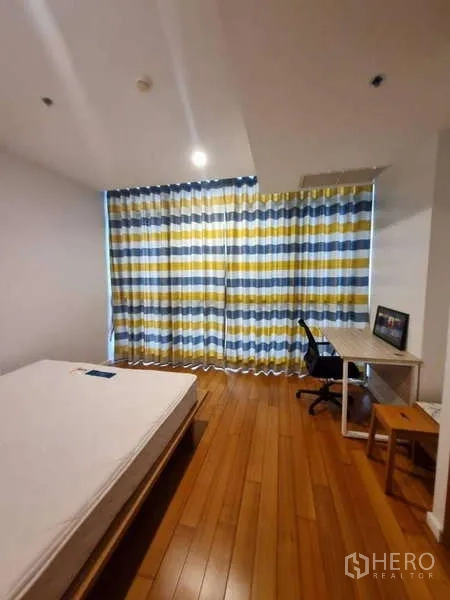 คอนโด ให้เช่าหรือขายในKhlong San, Bangkok - ห้องนอนรอง พื้นไม้ ผ้าม่านลายทาง พร้อมโต๊ะทำงานและเก้าอี้