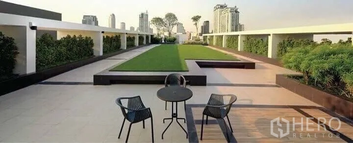 Condominium for rent in Watthana, Bangkok - Rooftop garden terrace with seating and panoramic Bangkok skyline views at the condominium.
