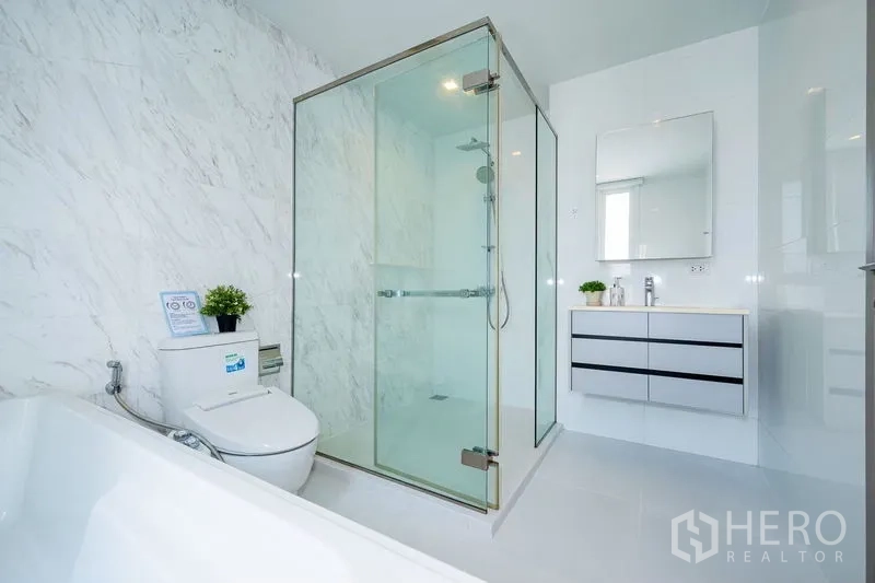 公寓 出租在Watthana, Bangkok - 大理石纹浴室，带玻璃淋浴间、盥洗台与坐便器。