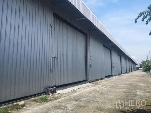 คลังสินค้า ให้เช่าในLam Luk Ka, Pathum Thani - ด้านนอกโกดังผนังเมทัลชีท ประตูเลื่อนขนาดใหญ่ ติดถนนภายในโครงการ