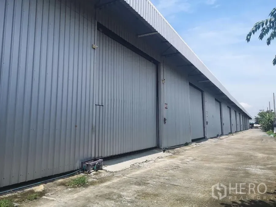 คลังสินค้า ให้เช่าในLam Luk Ka, Pathum Thani - ด้านนอกโกดังผนังเมทัลชีท ประตูเลื่อนขนาดใหญ่ ติดถนนภายในโครงการ